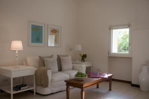 a living room with a white couch and a table at La Peschiera in Monopoli