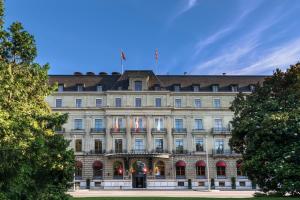 a large building with a flag on top of it at Hôtel Métropole Genève in Geneva