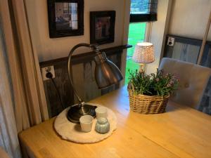 een bureau met een lamp en kopjes op een tafel bij B&B de Tuinfluiter in Nieuwleusen