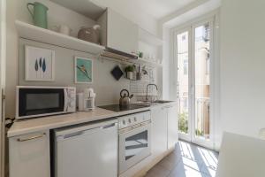 Biała kuchnia z kuchenką mikrofalową i kuchenką w obiekcie Fontana di Trevi Design Apartment w Rzymie
