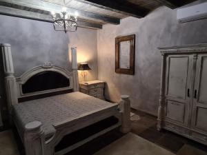 a bedroom with a bed and a dresser and a lamp at Resident Wellness Vendégház Békéscsaba in Békéscsaba