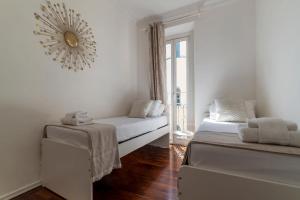 Pokój z 2 łóżkami i lustrem na ścianie w obiekcie Fontana di Trevi Design Apartment w Rzymie