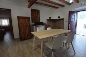 uma sala de jantar com uma mesa de madeira e cadeiras em Monte das Galhanas em Monte do Pigeiro