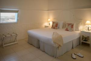 a bedroom with a large white bed and a window at La Peschiera in Monopoli