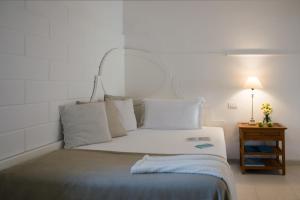 a bedroom with a white bed with a mirror on it at La Peschiera in Monopoli