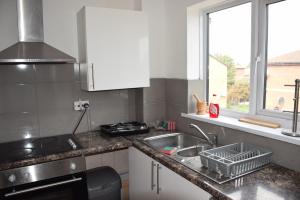 a kitchen counter with a sink and a window at One Bedroom Flat, Granary Road in Ponders End