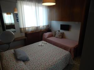a hotel room with two beds and a tv at Hotel Ristorante La Terrazza in Lido di Camaiore