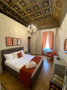 una camera con un grande letto e un lampadario a braccio di Loger Confort Residence & Apartments a Torino