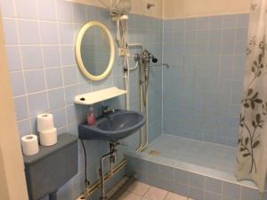 uma casa de banho azul com um lavatório e um espelho em Hermes Külalistemaja em Võru