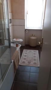 a bathroom with a tub and a toilet and a window at Hotel Ristorante La Terrazza in Lido di Camaiore