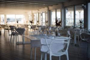 a dining room with white tables and chairs at La Peschiera in Monopoli