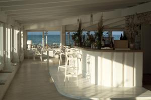 a room with chairs and a table and the ocean at La Peschiera in Savelletri di Fasano