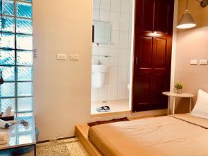 a bedroom with a bed and a bathroom with a shower at OYAJI Guesthouse 歐野基民家宿泊 in Tainan