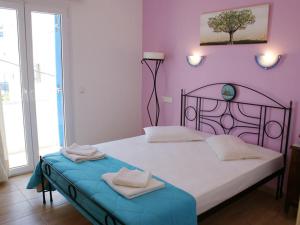 1 dormitorio con 1 cama con pared morada en Pension Verykokkos, en Naxos Chora