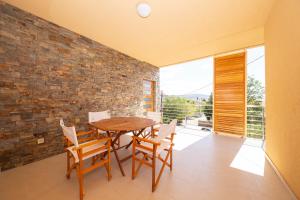 a dining room with a table and chairs and a brick wall at Villa francesca in Starigrad