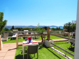 een tafel en stoelen op een tuin bij Panohome in Porto Pino