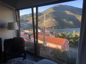 um quarto com uma grande janela com vista para uma montanha em casa das ameias em Folgosa