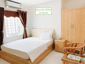 a bedroom with a bed and a sign that says pay use offer hours at Hoang Ngan 2 Hotel - TP. Vinh in Vinh