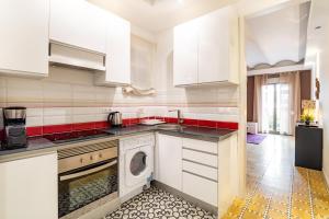 cocina con armarios blancos y lavadora en Stay U-nique Apartments Radas, en Barcelona