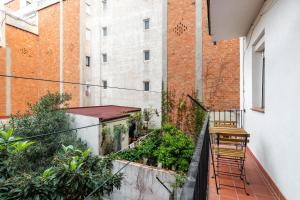 un balcón con 2 sillas y plantas en un edificio en Stay U-nique Apartments Radas, en Barcelona