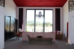 a living room with a couch and a large window at Herdade dos Alfanges "THE BARN" in Viana do Alentejo