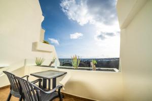 Habitación con mesa, sillas y ventana en Beatriz Costa & Spa, en Costa Teguise