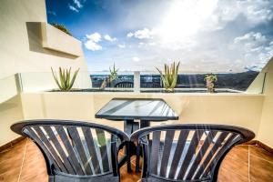 - un balcon avec vue doté de 2 chaises et d'une table dans l'établissement Beatriz Costa & Spa, à Costa Teguise