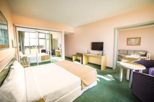 a hotel room with a bed and a living room at Beatriz Costa & Spa in Costa Teguise