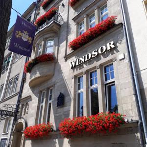 ein Gebäude mit roten Blumen vor einem Fenster in der Unterkunft Hotel Windsor in Düsseldorf