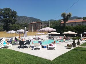 un groupe de personnes assises autour d'une piscine dans l'établissement Agriturismo La Palazza, à Sala Consilina