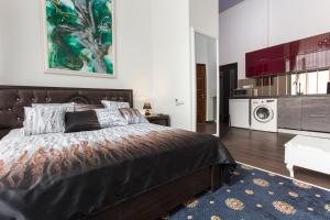 a bedroom with a large bed and a washing machine at Sumskaya Apartment Lux in Kharkiv