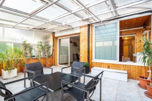 un patio con mesa negra y sillas en Stay U-nique Apartments Marina, en Barcelona