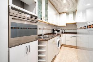 una cocina con armarios blancos y fregadero en Stay U-nique Apartments Marina, en Barcelona