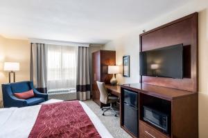 a hotel room with a bed and a desk and a television at Comfort Inn Bonner Springs Kansas City in Bonner Springs