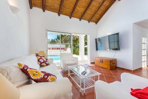 a living room with a white couch and a tv at Villa AL Fresco in Guia