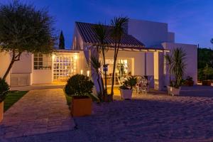 une maison avec des palmiers devant elle la nuit dans l'établissement Villa AL Fresco, à Guia