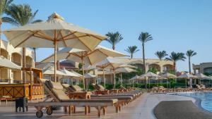 a resort with chairs and umbrellas and a swimming pool at Cleopatra Luxury Resort Sharm El Sheikh in Sharm El Sheikh