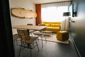 a room with a table and chairs and a couch at Live Hotels Bordeaux Lac in Bordeaux
