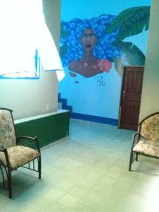 a wall with a painting of a woman in the water at Hostal Juan Lindo in San Pedro Sula
