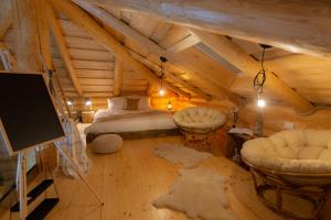 um quarto com uma cama e cadeiras num sótão em Resort Back To Nature em Bran