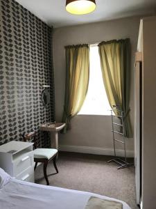 a bedroom with a bed and a chair and a window at Coach and Horses in Barnard Castle