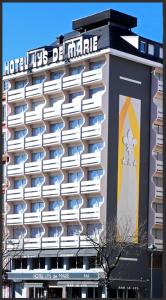 a hotel with a sign on the side of a building at Hôtel Lys de Marie in Lourdes