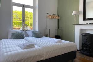 ein weißes Bett in einem Zimmer mit Kamin in der Unterkunft Authentic Stays - 6p-apartment in Eijsden