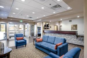 a lobby with two blue couches and a fireplace at Comfort Inn Bonner Springs Kansas City in Bonner Springs
