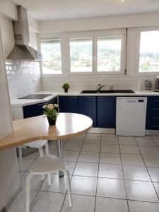 a kitchen with blue cabinets and a table and chairs at Le petit vosgien in Gérardmer