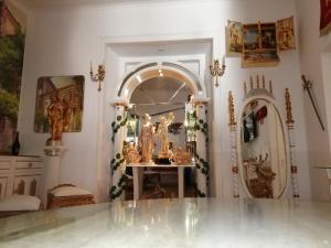 Pokój z lustrem i stołem z posągami w obiekcie Império Romano Guest House w mieście Beja