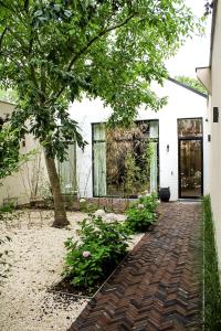 a brick walkway in front of a house with a tree at Oscar in Ghent