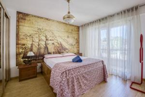 尼斯的住宿－Greeter-Appartement Lumineux avec vue sur la mer，卧室配有一张床,墙上挂有绘画作品