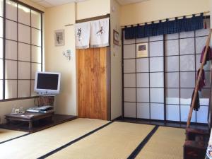 a room with a tv and a door and a tv at Minshuku Chambres d'hôtes japonaises in Thiers
