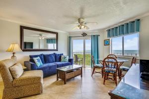 a living room with a blue couch and a table and chairs at Oceanside Retreat in Tavernier
